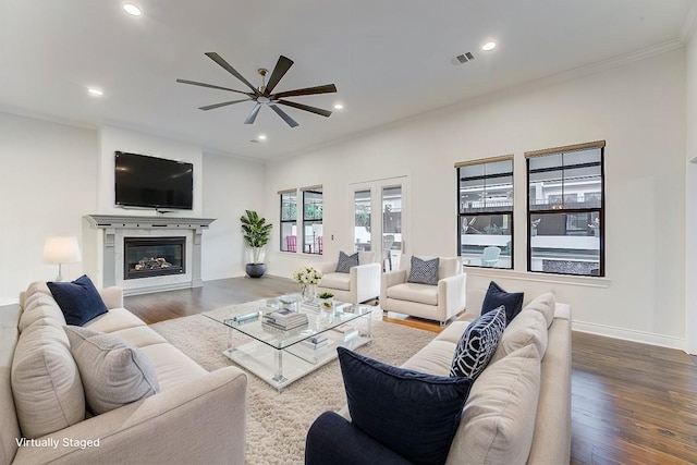 living room featuring ceiling fan, dark hardwood / wood-style flooring, and crown molding