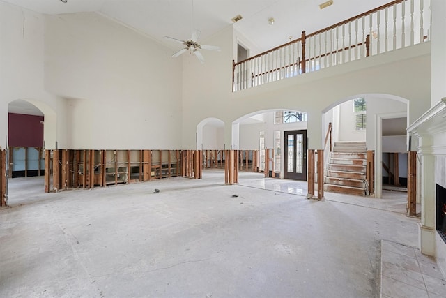 interior space with ceiling fan, french doors, and a high ceiling