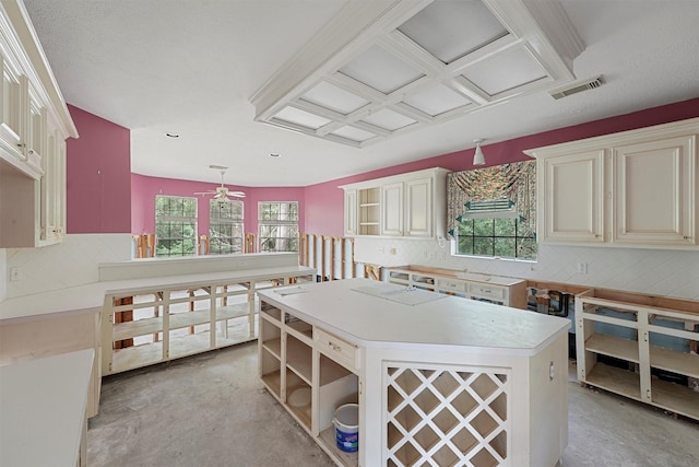 kitchen featuring ceiling fan, a center island, hanging light fixtures, and a wealth of natural light