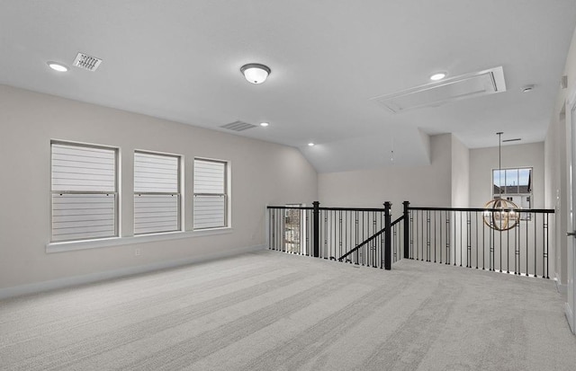 spare room featuring carpet floors, vaulted ceiling, and a notable chandelier