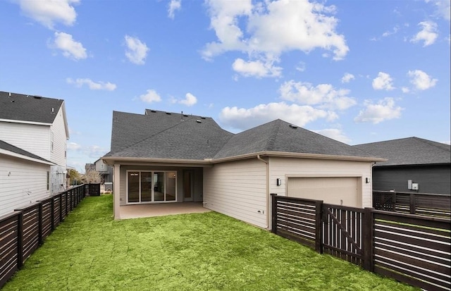 back of house featuring a lawn and a garage