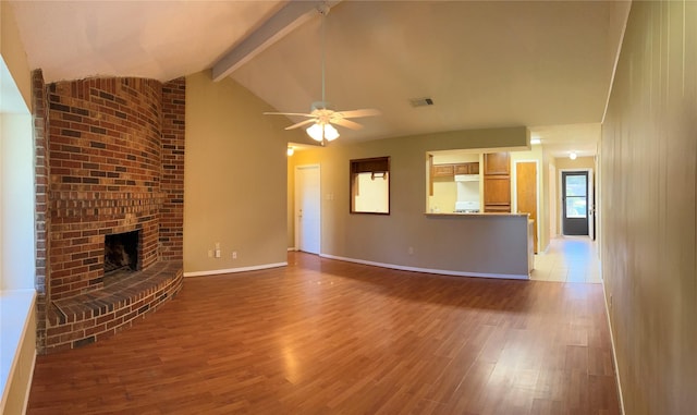 unfurnished living room featuring lofted ceiling with beams, ceiling fan, light hardwood / wood-style flooring, and a brick fireplace