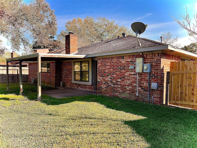 rear view of house featuring a yard and a patio