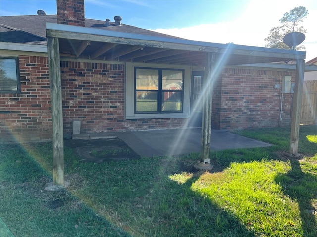 back of property with a patio and a lawn