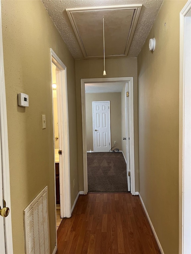 hall featuring dark hardwood / wood-style flooring and a textured ceiling