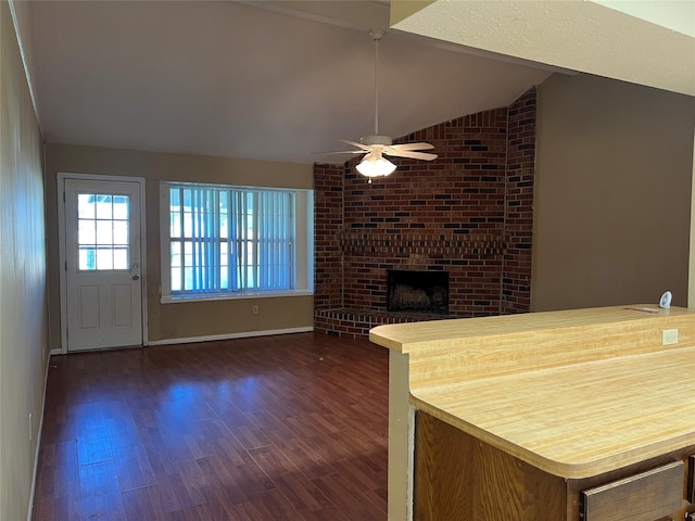 kitchen featuring ceiling fan, dark hardwood / wood-style flooring, a fireplace, and vaulted ceiling