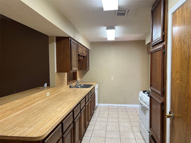 kitchen featuring white appliances, sink, light tile patterned floors, a textured ceiling, and dark brown cabinetry