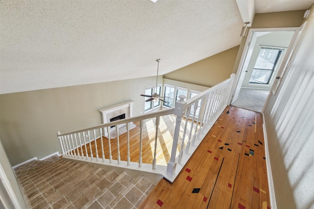 stairway featuring lofted ceiling and a textured ceiling