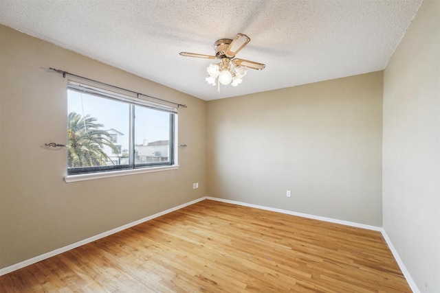 spare room with ceiling fan, hardwood / wood-style floors, and a textured ceiling