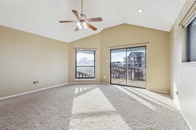 unfurnished room with vaulted ceiling, carpet floors, ceiling fan, and a textured ceiling