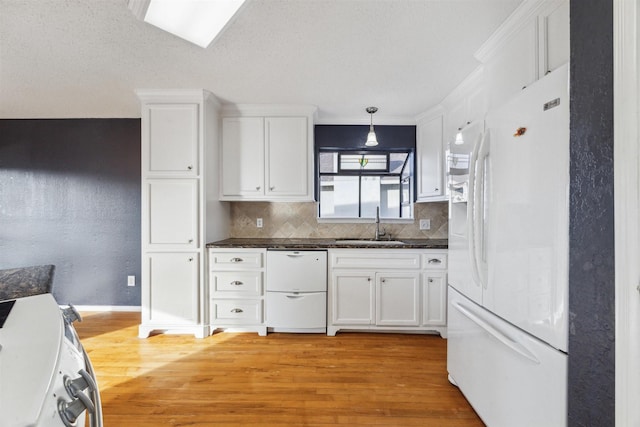 kitchen featuring white cabinetry, hanging light fixtures, white appliances, light hardwood / wood-style floors, and decorative backsplash