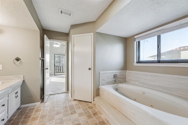 bathroom featuring vanity, a washtub, and a textured ceiling