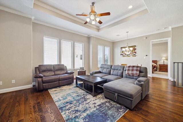 living room featuring ceiling fan with notable chandelier, dark hardwood / wood-style floors, a raised ceiling, and crown molding