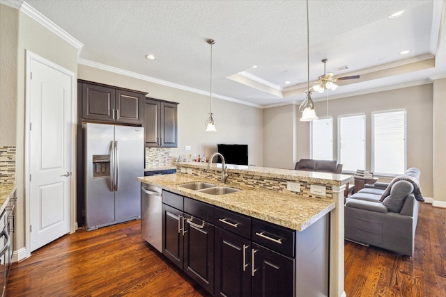 kitchen featuring sink, decorative backsplash, dark hardwood / wood-style floors, an island with sink, and appliances with stainless steel finishes