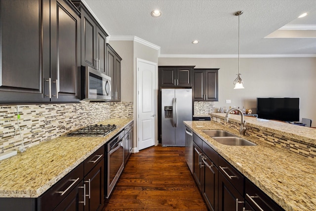 kitchen featuring decorative light fixtures, ornamental molding, sink, and appliances with stainless steel finishes