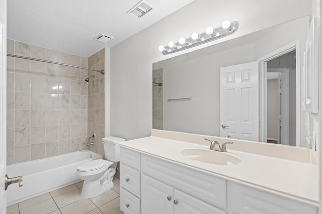 full bathroom with tiled shower / bath combo, toilet, vanity, tile patterned floors, and a textured ceiling