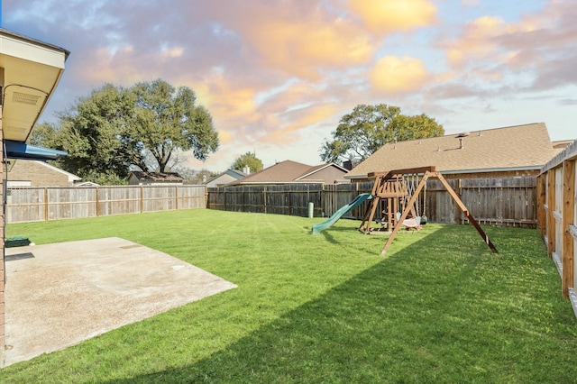 yard at dusk featuring a patio and a playground