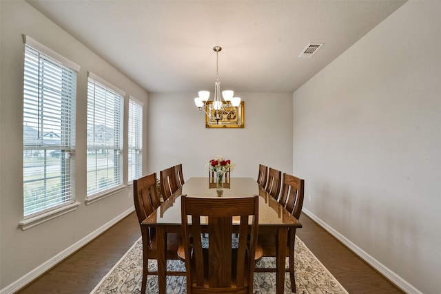 dining room featuring dark hardwood / wood-style floors and an inviting chandelier