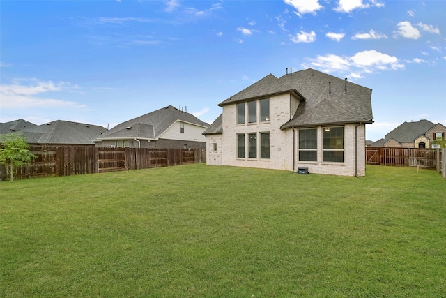 rear view of house featuring a lawn