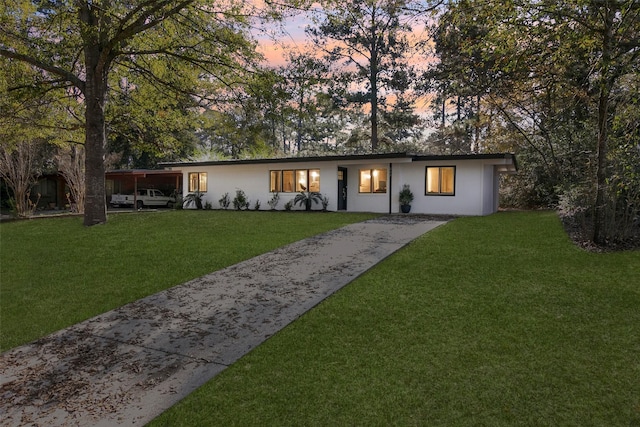 ranch-style home featuring a yard and a carport