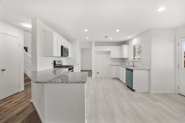 kitchen featuring light stone counters, sink, white cabinets, and appliances with stainless steel finishes