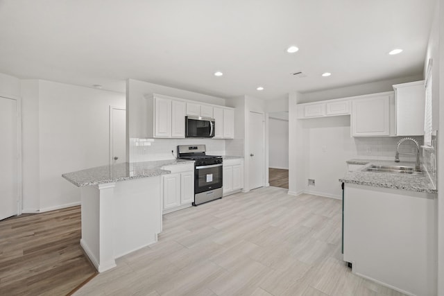 kitchen with stainless steel appliances, white cabinetry, and tasteful backsplash