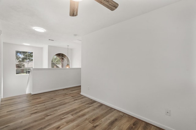 empty room with hardwood / wood-style floors and ceiling fan