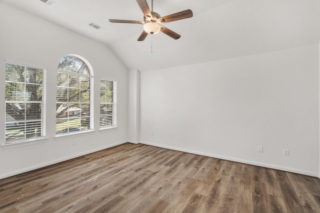 spare room with wood-type flooring, lofted ceiling, ceiling fan, and a healthy amount of sunlight