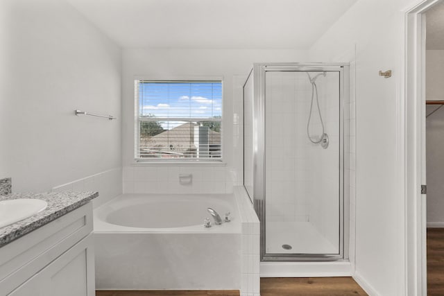 bathroom with vanity, wood-type flooring, and shower with separate bathtub