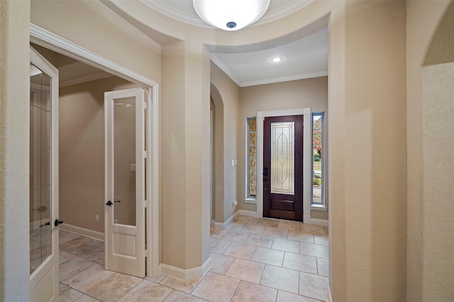 foyer entrance with baseboards, arched walkways, crown molding, and french doors