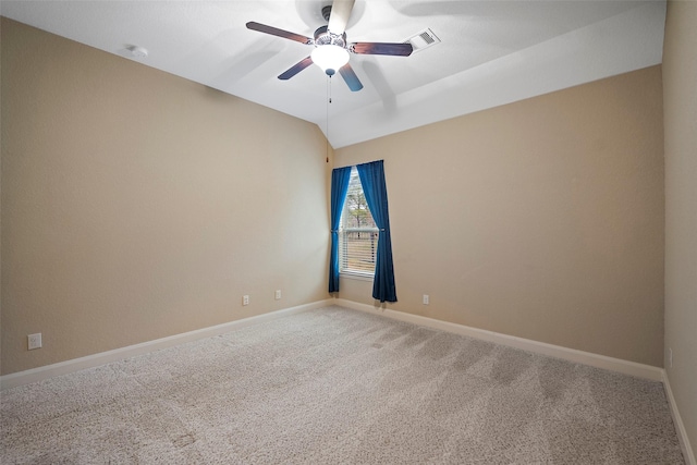 carpeted spare room with lofted ceiling, ceiling fan, visible vents, and baseboards