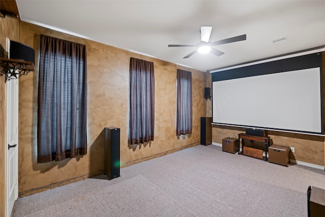 carpeted cinema room with visible vents and ceiling fan