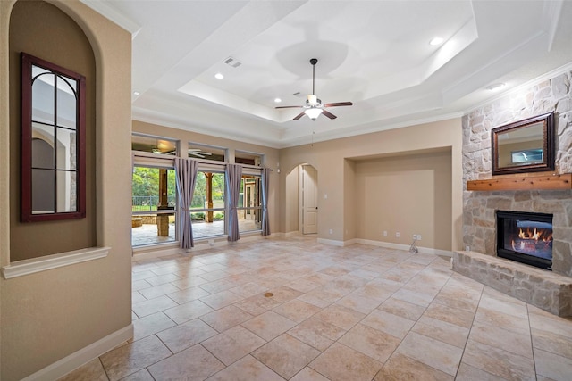 unfurnished living room with a fireplace, a raised ceiling, visible vents, and baseboards