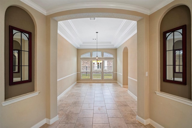 tiled entrance foyer with an inviting chandelier, a tray ceiling, and ornamental molding