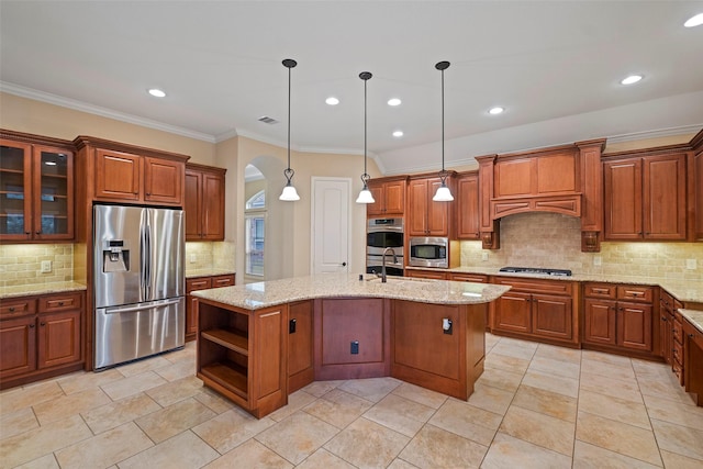 kitchen featuring pendant lighting, stainless steel appliances, a kitchen island with sink, and tasteful backsplash