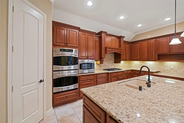 kitchen featuring decorative light fixtures, light tile patterned floors, stainless steel appliances, tasteful backsplash, and a sink