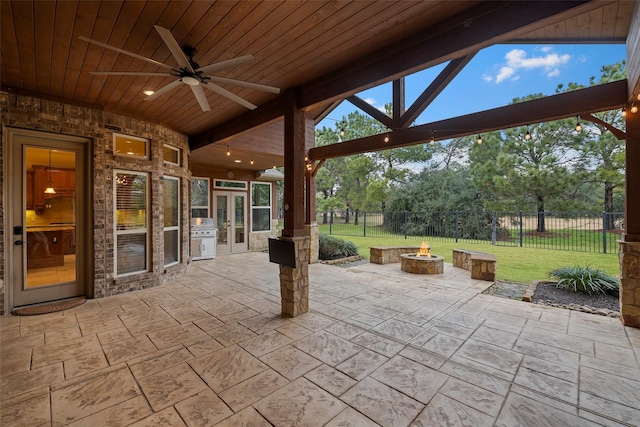 view of patio / terrace featuring french doors, area for grilling, ceiling fan, and a fire pit