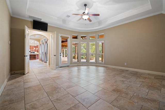 unfurnished room featuring visible vents, arched walkways, and a raised ceiling