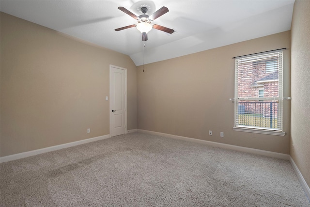 spare room featuring lofted ceiling, a ceiling fan, baseboards, and carpet flooring