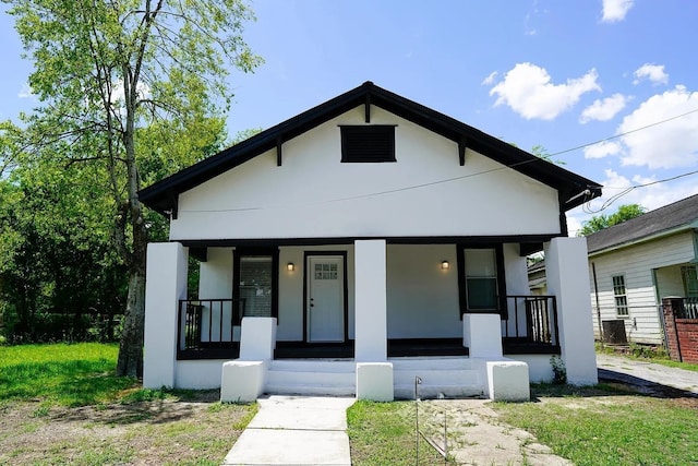 view of front facade featuring covered porch and a front yard