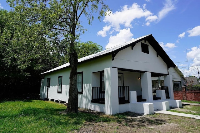 view of home's exterior featuring a porch and a lawn