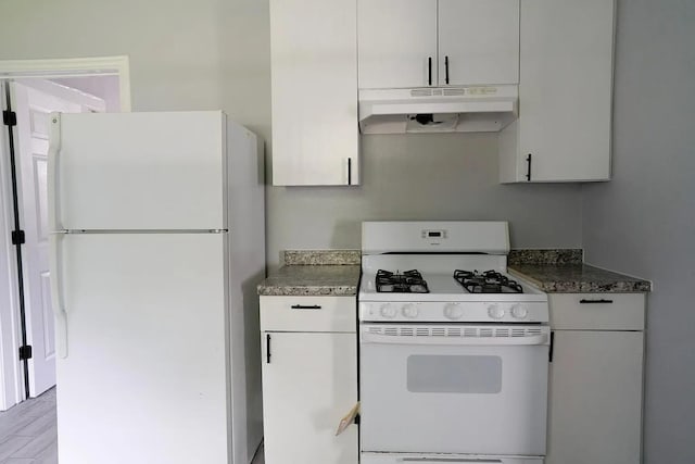 kitchen with white cabinets, white appliances, and dark stone counters