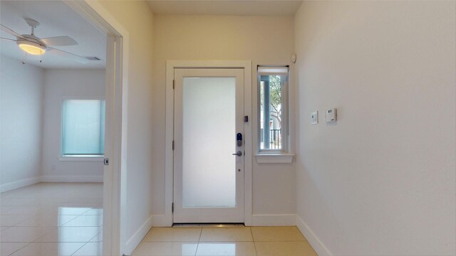 doorway to outside featuring ceiling fan and light tile patterned flooring