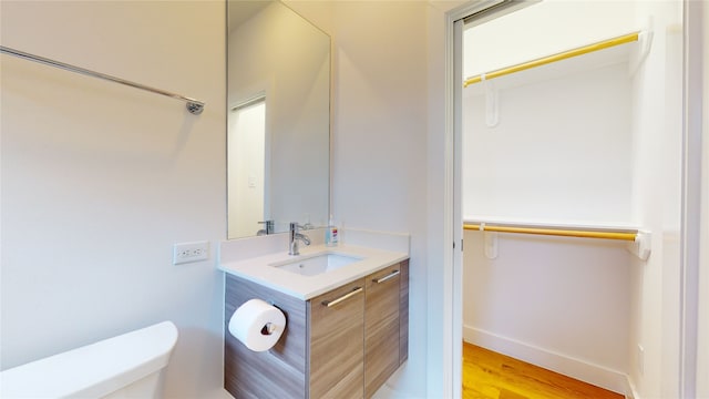 bathroom with vanity, hardwood / wood-style flooring, and toilet