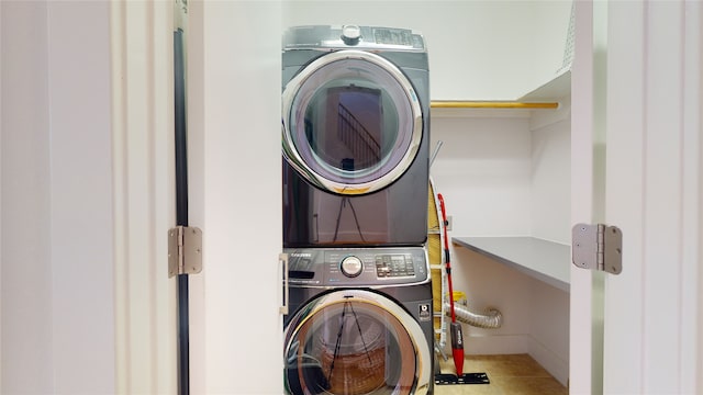 laundry room with tile patterned floors and stacked washer and clothes dryer