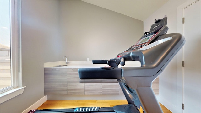 interior space featuring lofted ceiling, sink, and hardwood / wood-style floors