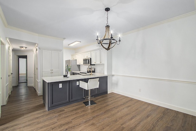 kitchen with stainless steel appliances, kitchen peninsula, pendant lighting, a breakfast bar area, and white cabinets