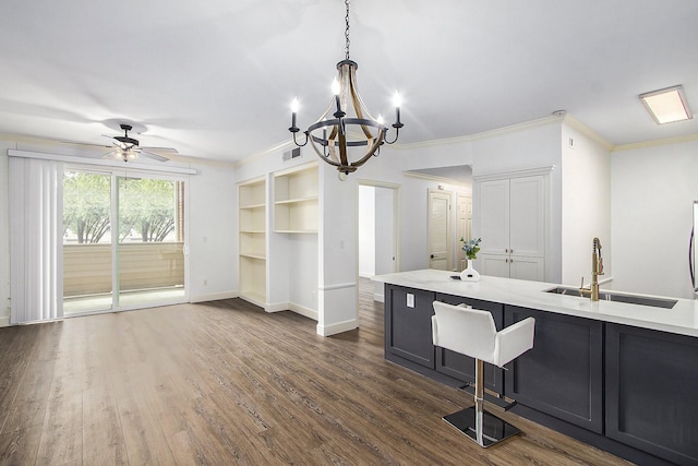 kitchen featuring sink, ceiling fan with notable chandelier, decorative light fixtures, and ornamental molding