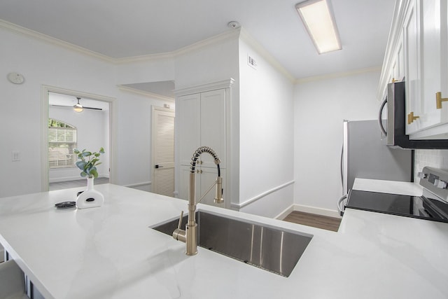 kitchen featuring kitchen peninsula, sink, white cabinets, and range