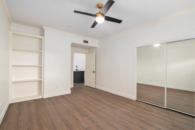 unfurnished bedroom featuring ceiling fan, dark hardwood / wood-style floors, crown molding, and a closet